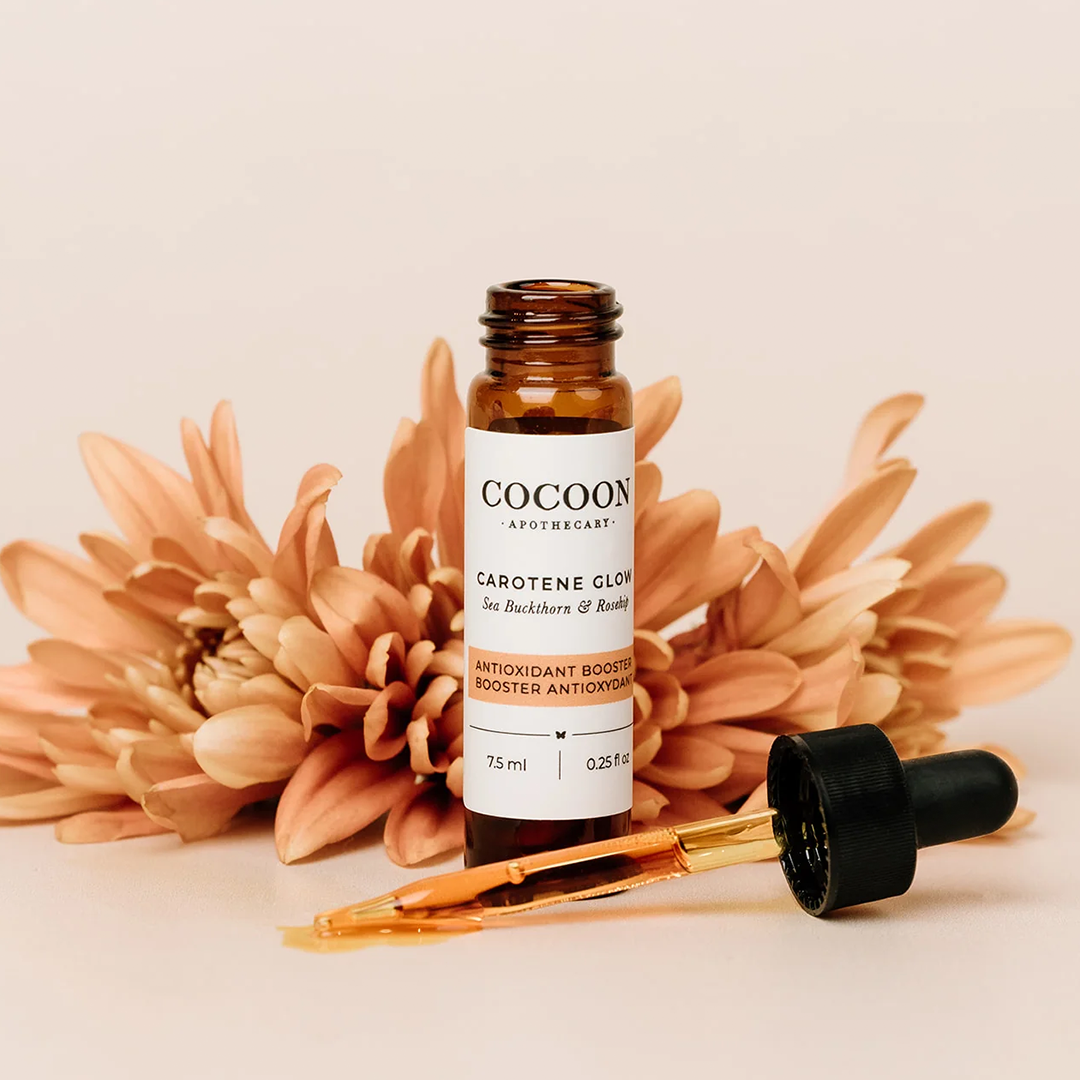 image: cocoon apothecary carotene glow lifestyle flowers, depicting the skincare product in a lifestyle setting with flowers.